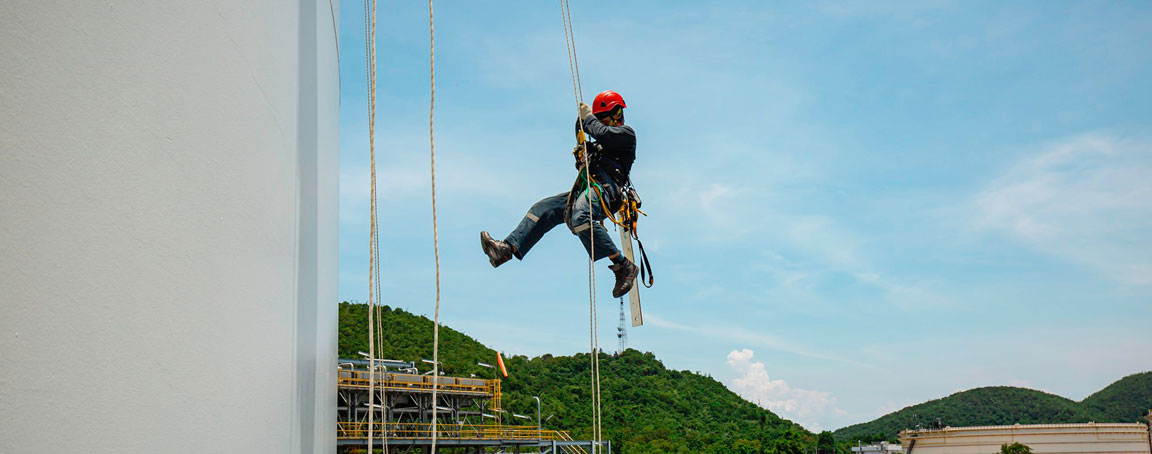 Homme qui descend en rappel à l'aide de deux cordes